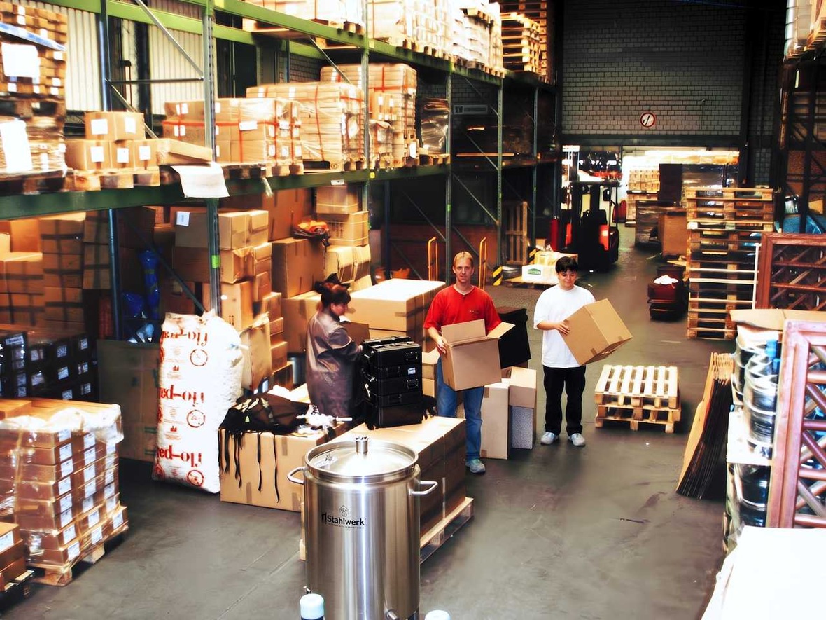Mitarbeiter im Versandlager bei der Verpackung und Kommissionierung professioneller Getränkerucksäcke für den internationalen Versand.